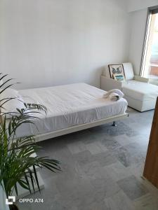 滨海卡涅Résidence Le Persepolis 50 m de la mer的一间卧室配有一张床和盆栽植物