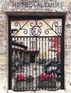 桑提亚纳德玛阿尔塔米拉酒店的铁艺门,带花卉和桌椅