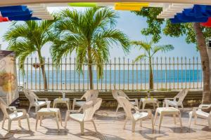 圣玛尔塔圣拓利尼精品酒店 的一个带椅子和桌子的庭院,并种植了棕榈树