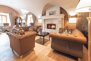 恩斯河谷艾根IMLAUER Hotel Schloss Pichlarn的客厅配有皮革家具和壁炉