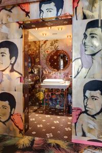 安特卫普Small Luxury Hotel De Witte Lelie的浴室设有一面镜子,墙上挂着一幅画