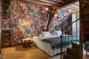 安特卫普Small Luxury Hotel De Witte Lelie的一间卧室配有色彩缤纷的花卉壁画