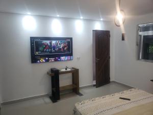 瓜鲁柳斯suite Perto do aeroporto de guarulhosAv Jovita 401的墙上配有平面电视的房间