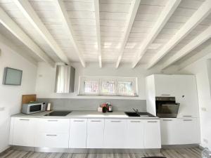 Pecetto di ValenzaVILLA GIOIA - Piscina nel Monferrato的厨房配有白色橱柜和格子天花板