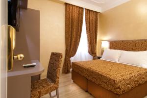 罗马费里尼酒店的配有一张床和一把椅子的酒店客房