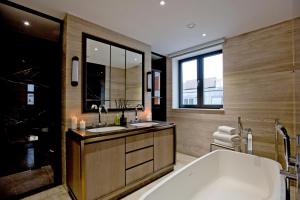 伦敦37GS Residences的浴室配有两个盥洗盆和浴缸。