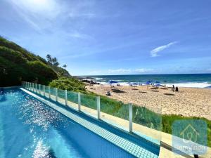 萨尔瓦多Apartamento completo e pé na areia no Rio Vermelho的背景海滩的游泳池