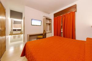 维拉卡洛斯帕兹埃尔康达多酒店的一间卧室配有橙色的床和电视