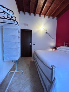 皮恩扎Valdorcia Belvedere b&b的卧室配有白色的床和红色的墙壁