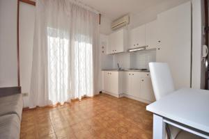 比比翁Residence Ranieri的一间厨房,配有白色的橱柜和大窗户