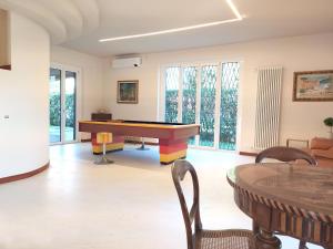 罗镇Rho Mind Villa的客厅配有乒乓球桌和椅子