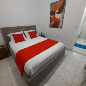 萨兰达Luxury Dennis Home的一间卧室配有一张带红色枕头的大床