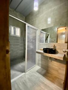 杜马格特Hai Inn的一间带玻璃淋浴和水槽的浴室
