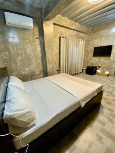 杜马格特Hai Inn的配有电视的客房内的一张大床