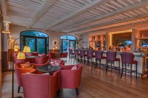 加尔加斯Coquillade Provence的一间设有红色椅子的餐厅和一间酒吧
