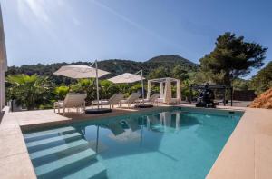 伊维萨镇Villa Romeo的一个带躺椅和遮阳伞的游泳池