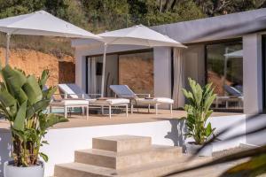 伊维萨镇Villa Romeo的房屋内带椅子和遮阳伞的庭院
