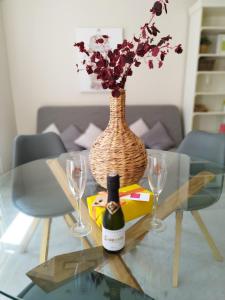塞维利亚Suite Apartament Cathedral的玻璃桌,带一瓶葡萄酒和两杯