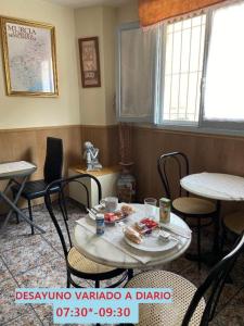 圣佩德罗-德尔皮纳塔尔阿尔塞酒店的配有桌椅的房间和一张桌子,上面有食物