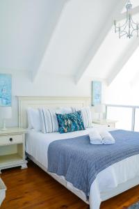 圣弗朗西斯湾Cottage with a View的一间卧室配有白色的床、蓝色的毯子和枕头