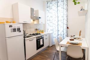 墨西拿Appartamento nel cuore di Messina的一间厨房,配有白色家电和桌椅