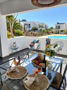 维拉韦德Casilla de Costa的一个带游泳池的阳台,配有一张带水果和葡萄酒的桌子