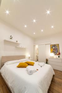 墨西拿Appartamento nel cuore di Messina的白色卧室配有一张白色大床和黄色枕头
