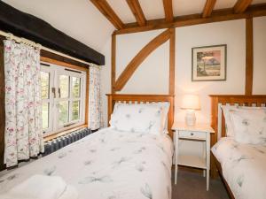 坎特伯雷Wren Cottage的带窗户的客房内的两张床