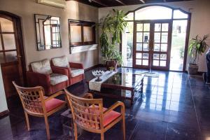 里奥夸尔托圣卡塔利娜酒店的客厅配有沙发和桌椅