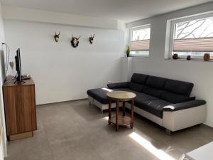 温特贝格Berghof Schmitte的客厅配有黑色沙发和桌子