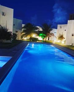 MaxaranguapeChalé Paraíso -Maracajaú 4- Casa 38 - Beira-mar的夜间大型游泳池,灯光蓝色