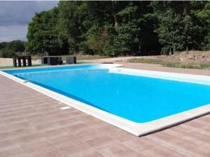 Saint-Mars-du-DésertChateau du Perray的一座大型蓝色游泳池,位于铺有瓷砖的庭院内