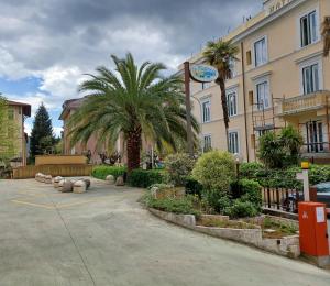 菲乌吉Appartamento Fiuggi Terme的棕榈树建筑前的停车场