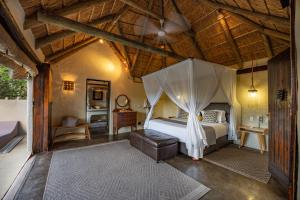 阿马卡拉保护区Safari Lodge - Amakhala Game Reserve的一间卧室配有一张带天蓬的床
