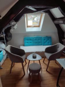 鲁昂Rouen的配有床和两把椅子及一张桌子的房间