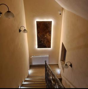 GolczowiceMARMI Noclegi的楼梯,有两盏灯,墙上有一张照片