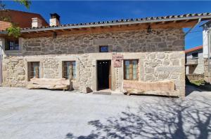 Villar de CornejaLa Cantina casas rurales paredes的石头建筑,前面有一扇门