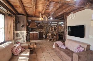 Villar de CornejaLa Cantina casas rurales paredes的带沙发和平面电视的客厅