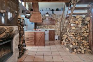 Villar de CornejaLa Cantina casas rurales paredes的厨房配有木制橱柜和壁炉。