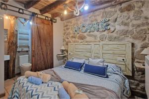 Villar de CornejaLa Cantina casas rurales paredes的一间卧室配有一张带蓝色枕头的大床