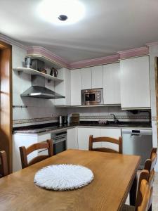 埃利松多Arotzetxea的一间带木桌的厨房和一间带白色橱柜的厨房