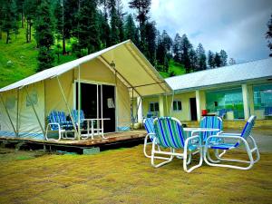 TālValhalla Resort Kumrat的四把椅子和一张桌子,在帐篷前