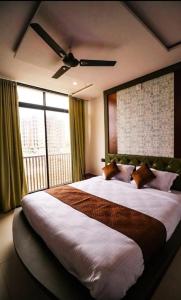 乌代浦Hotel LAAKHAN BY GHUMO UDAIPUR的一间卧室设有一张大床和大窗户