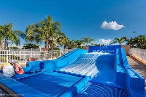 基西米Beautiful Townhome wPool &FREE Resort Access的棕榈树度假村的蓝色水滑梯