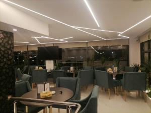 Umm el ‘AmadDurrat Al Israa的一间带桌椅和电视的餐厅