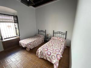 贝赫尔-德拉弗龙特拉Mayorazgo的一间卧室设有两张床和窗户。