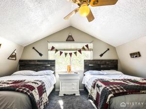 达克科里克村Woodchuck Cabin的阁楼卧室设有两张床和窗户。