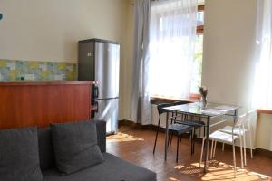 格但斯克Kaletnicza Old Town Apartment的厨房配有沙发、桌子和冰箱。