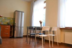 格但斯克Kaletnicza Old Town Apartment的厨房配有桌椅和冰箱。
