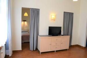 格但斯克Kaletnicza Old Town Apartment的一间卧室配有一张床和一个带电视的梳妆台